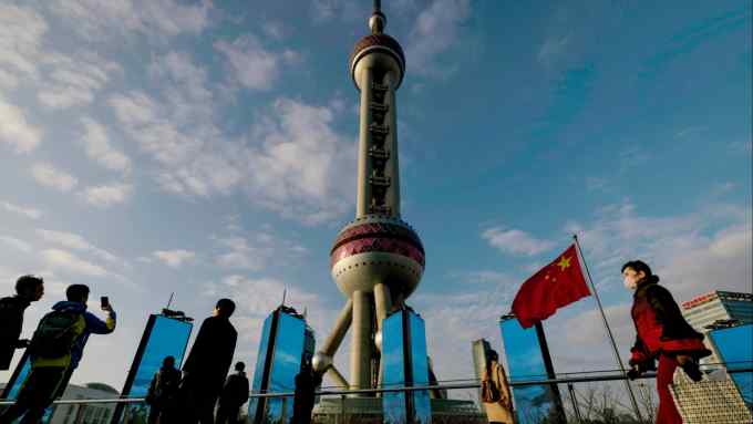 People walk below Oriental Pearl Tower in the Liuiazui financial hub, in Shanghai