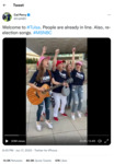 Two girls with wavy, long blond hair, jeans, and Trump T-­shirts appear alongside their father and other singers. The father, pictured in the middle, holds a small speaker. The woman on the left holds a guitar.