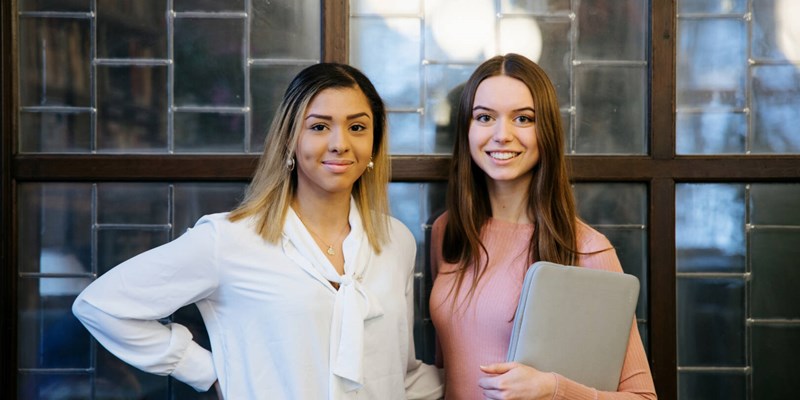 two students smiling in front of the camera