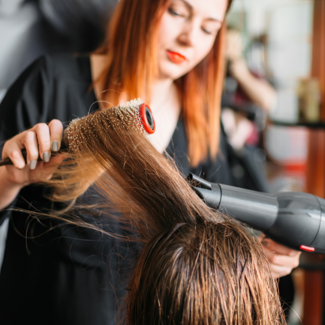 Image of a beauty school student performing hair service on a client