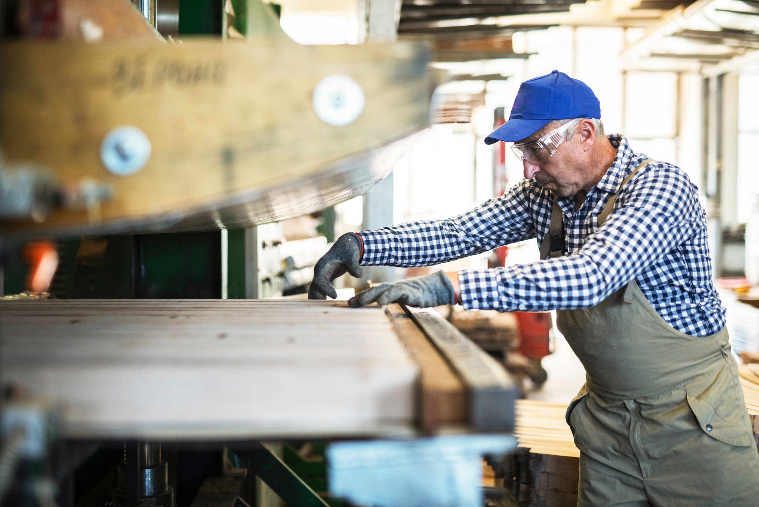 Man adjusting wood in a machine.