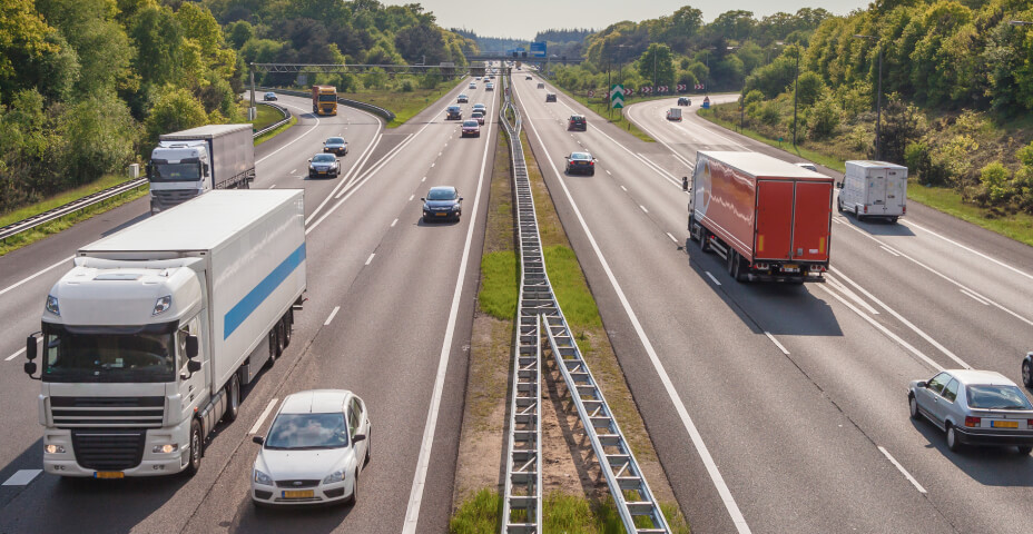 Četru joslu šoseja ar kravas un pasažieru auto abās pusēs.