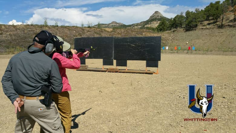 NRA Instructor closely watches a woman safely shooting a defensive shotgun at the Whittington University Range