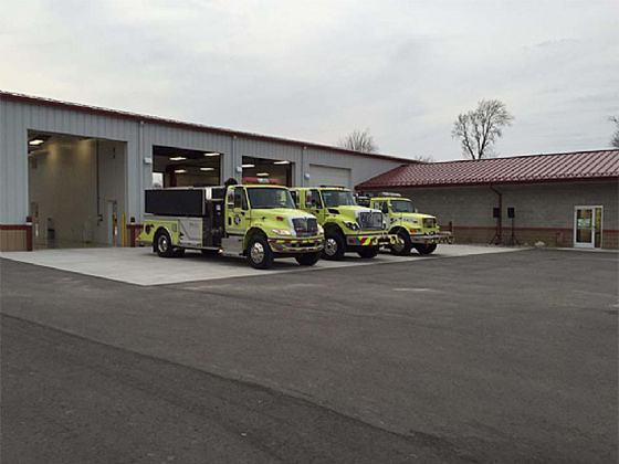 Three fire trucks parked outside a fire station.