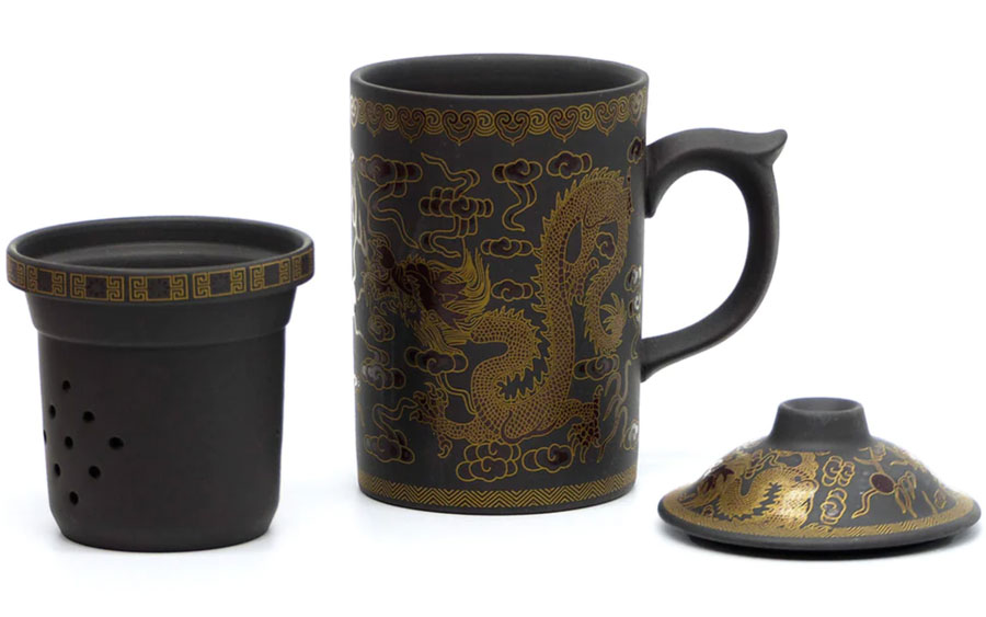 Tea mug, lid, and strainer with a dragon pattern on it.