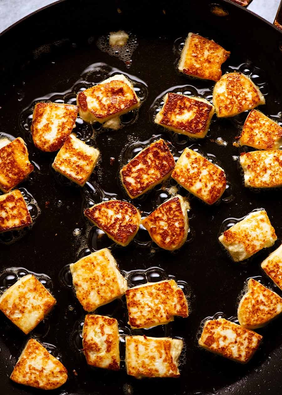 Paneer being pan fried in a skillet