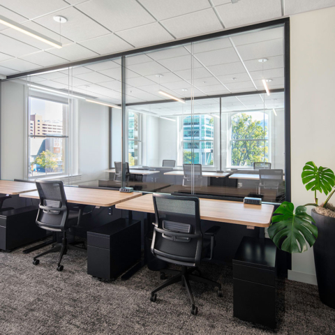 desks with chairs near a large office window