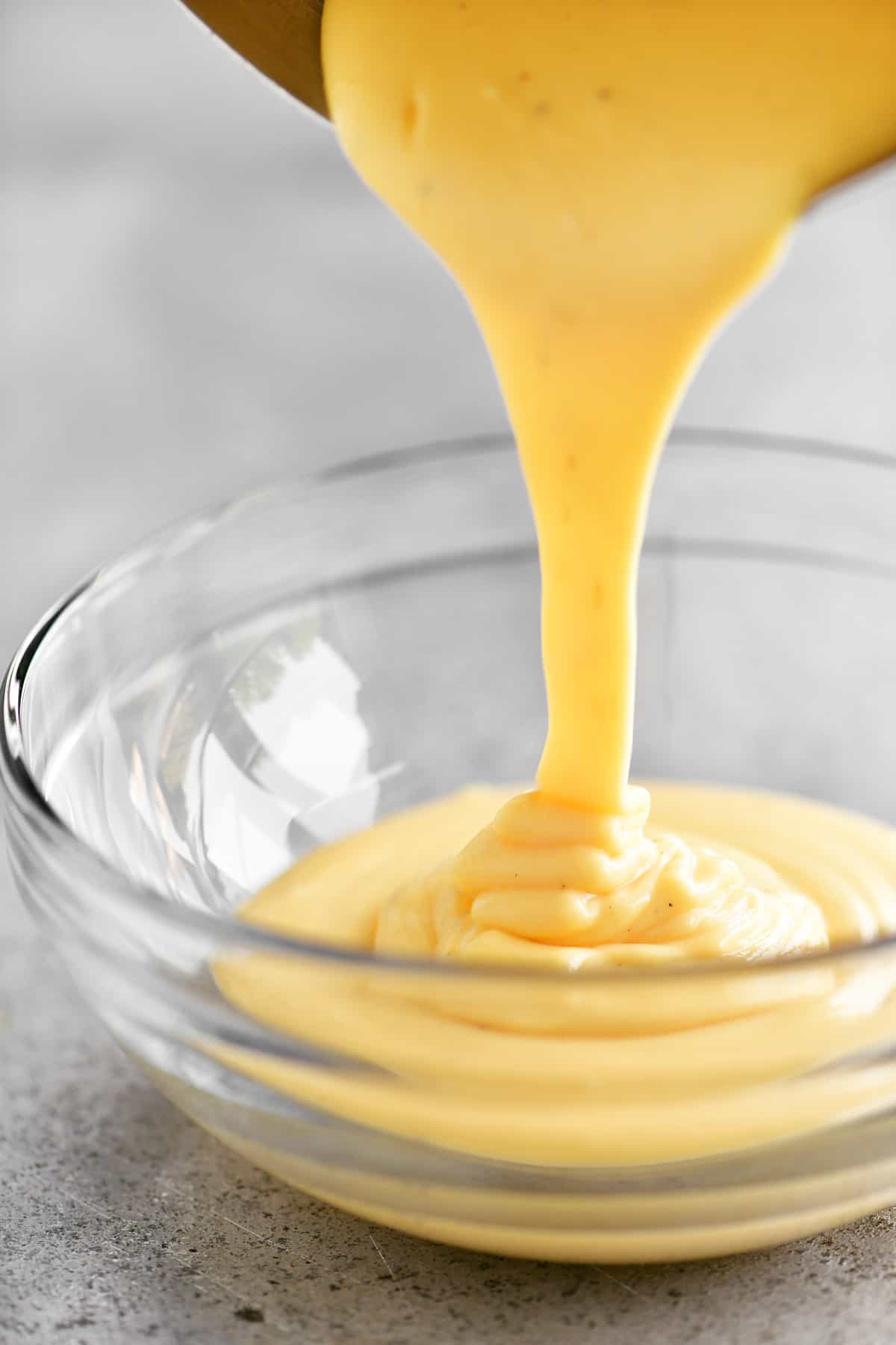 pouring the cheese sauce into a glass bowl