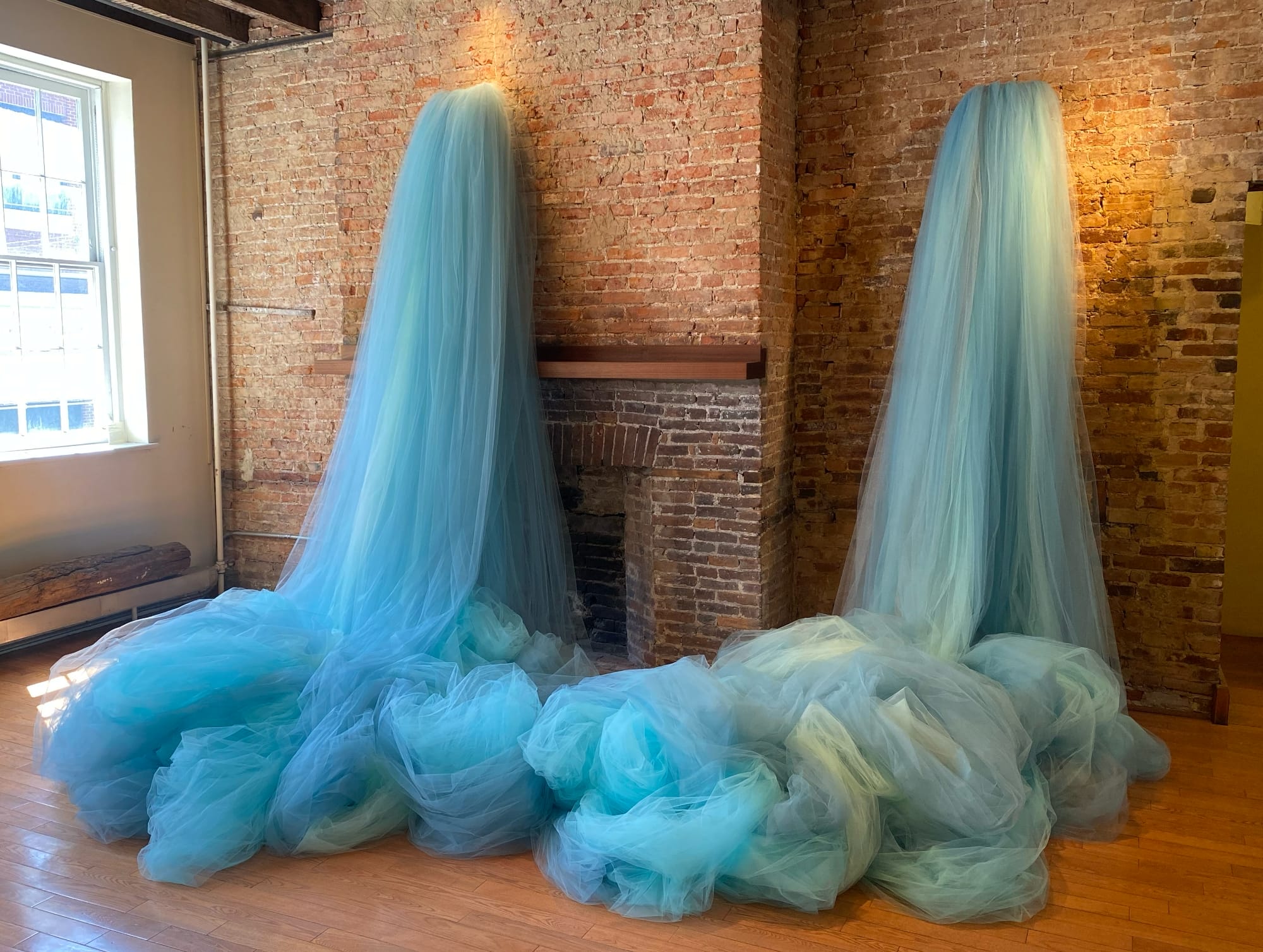 blue tulle spills from a brick wall in two places