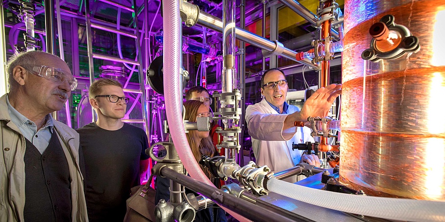 A researcher explains a machine to visitors.