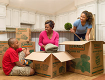 A family placing items into moving boxes.