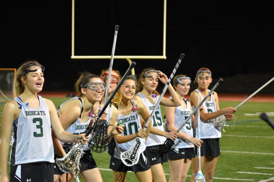 Stick check! The girls cheer on their fellow teammates right before the start of the game. 