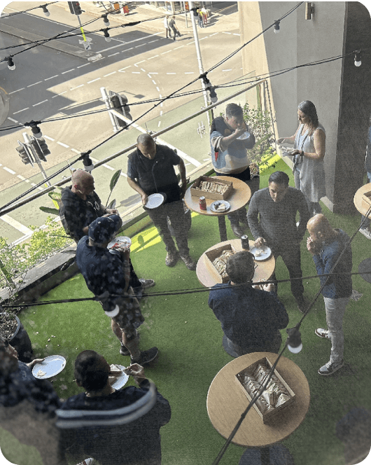 People at standing desks eating sandwiches and chatting