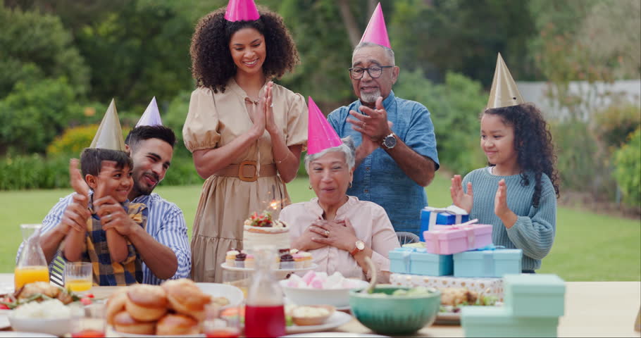 Family, clapping hands and happy with hat at birthday party for celebration, surprise or sparkler in garden of home. Grandparents, parents and kids with applause for gathering and event in backyard