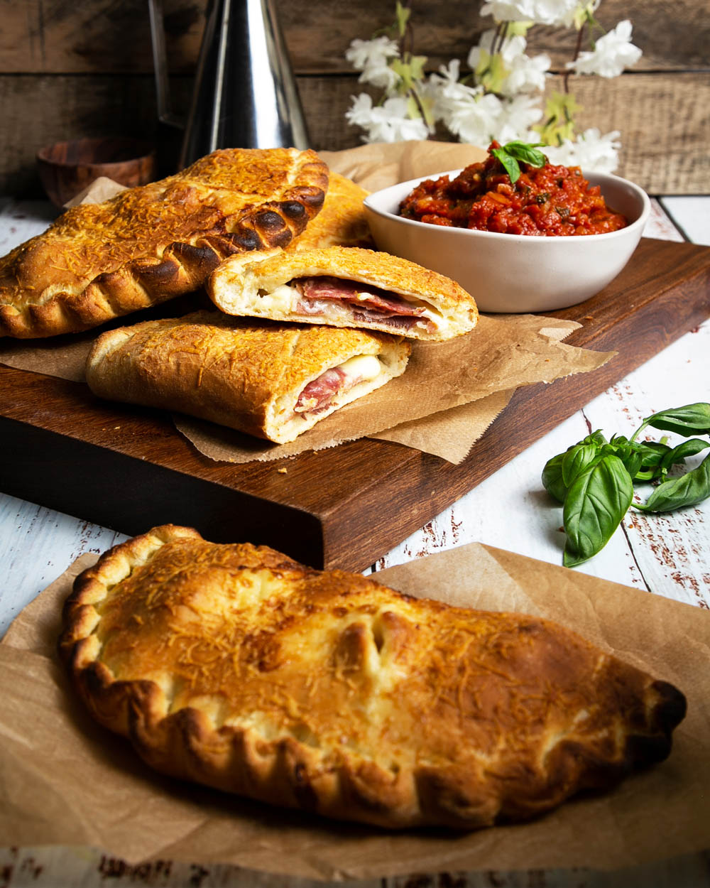 Calzone on a cutting board with marinara sauce