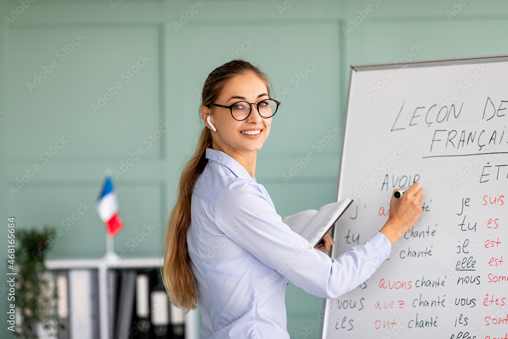 Lecture concept. Millennial female French teacher standing near ...