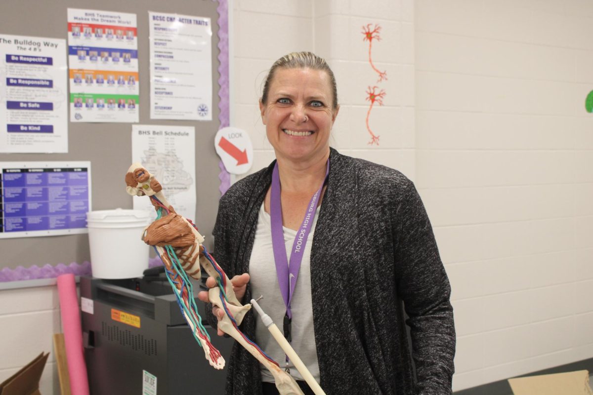 Duncan-Flory holding up a model used to inform her classes of the human body. 