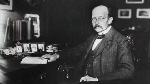 a black and white photo of a man sitting at a desk.