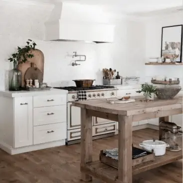 Farmhouse kitchen with wood island, Pergo flooring in Riverbend Oak, White shaker cabinets and french range.