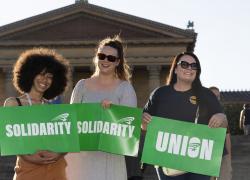 A photo of three women holding signs.