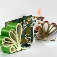 handmade rolled phone book page letter holders decorated with green and red wide ribbon on each roll displayed with cards placed between rolls