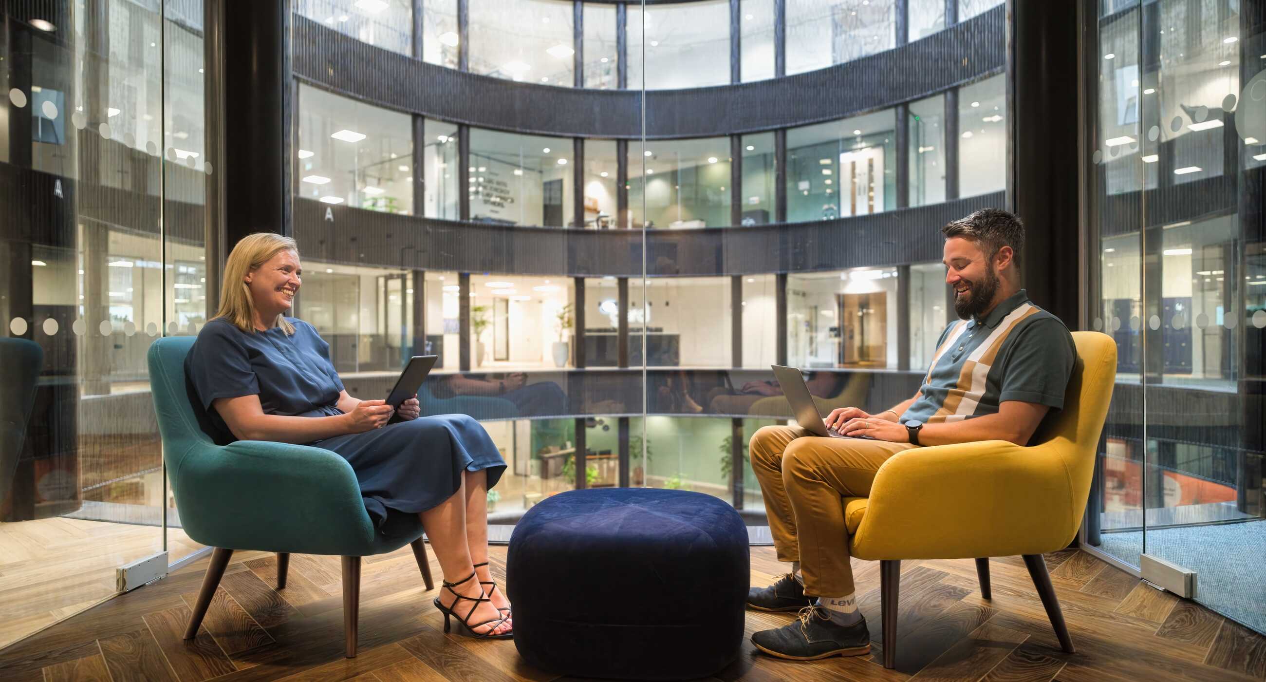 A photograph of smiling Trustpilot employees collaborating in sunshine.