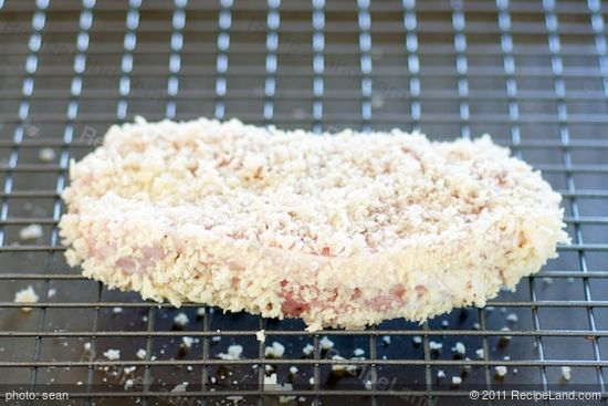 Place the prepared pork chops onto a wire rack that's set in a large baking sheet. 