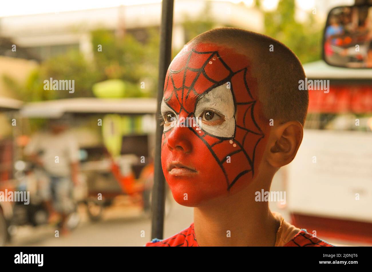 portrait of an 8 year old mixed race boy (Cambodian - American) with his face painted for Halloween. Phnom Penh, Cambodia. © Kraig Lieb Stock Photo