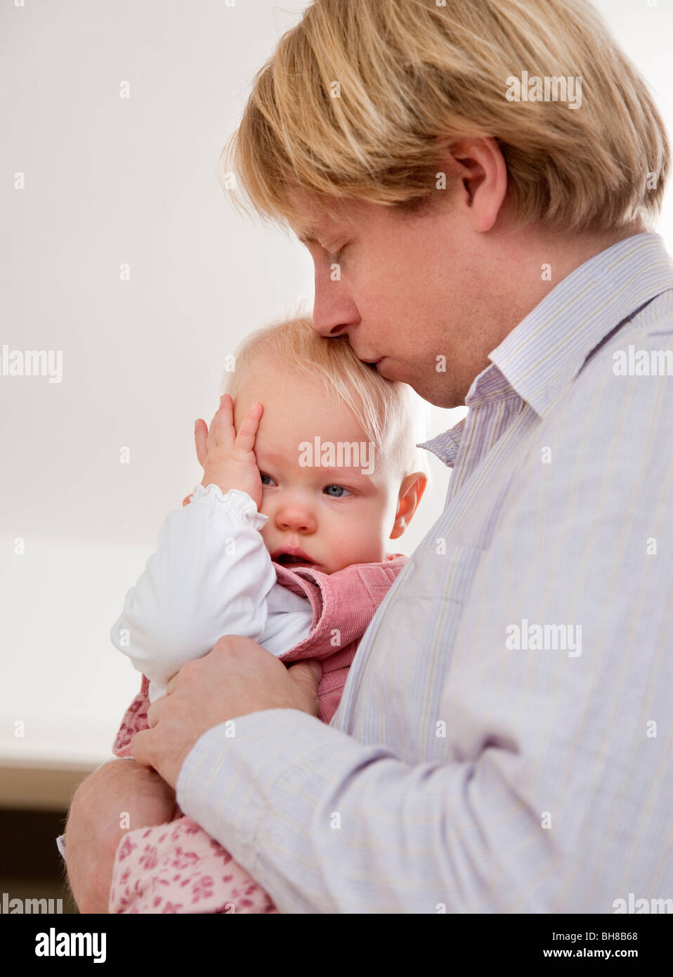 father comforting crying baby Stock Photo