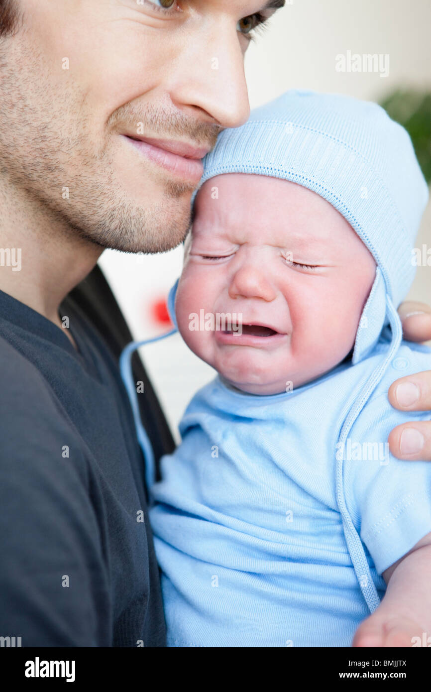 Baby boy crying in fathers arm Stock Photo