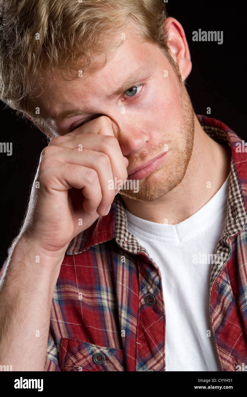 Sad boy rubbing eyes crying Stock Photo