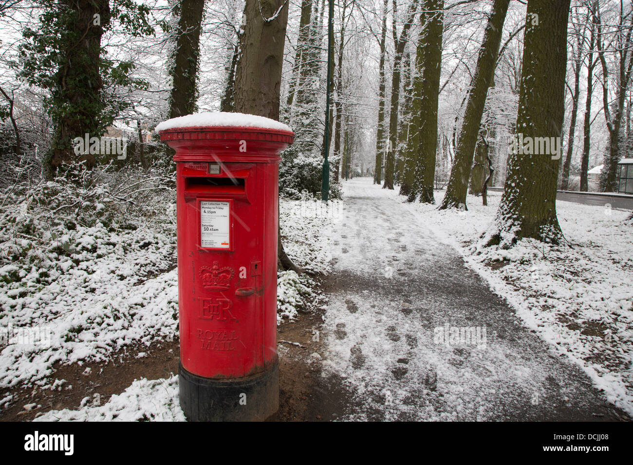 Red Pillar Box, snow and trees Stock Photo