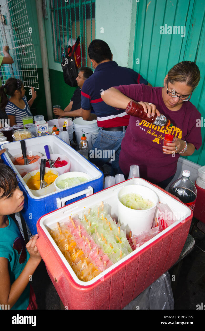 A woman sells ice lollies to children in a food festival in Puebla city, Mexico Stock Photo