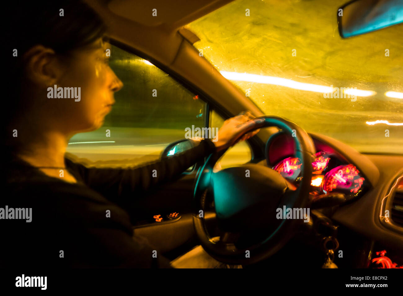 Woman driving car at night Stock Photo