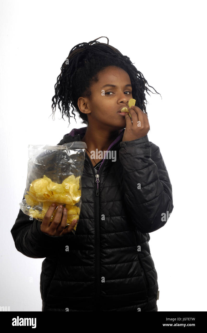 teenage girl eating chips Stock Photo