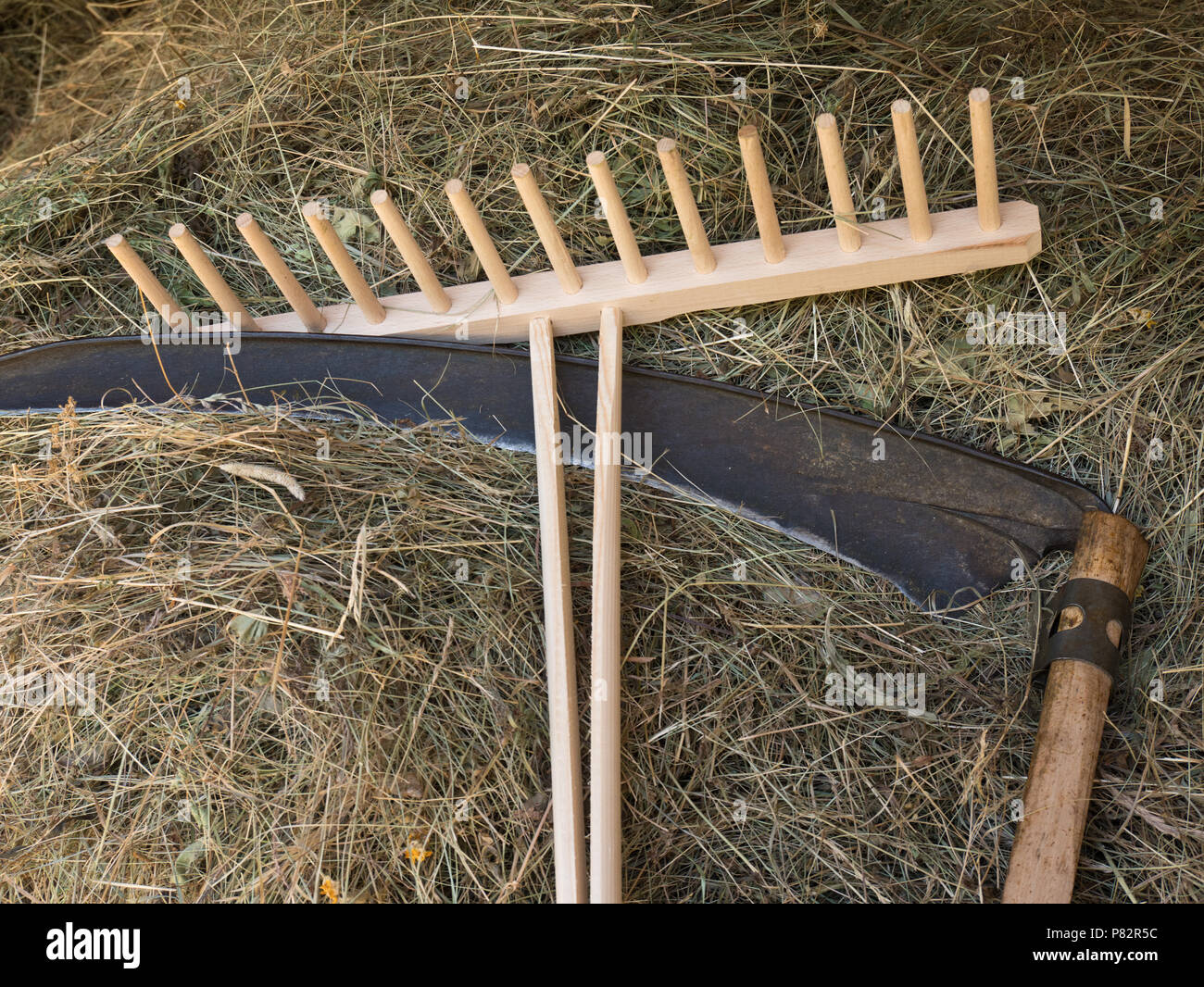 A scythe and a rake with  hay Stock Photo