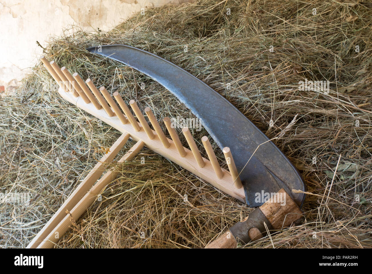 A scythe and a rake with  hay Stock Photo