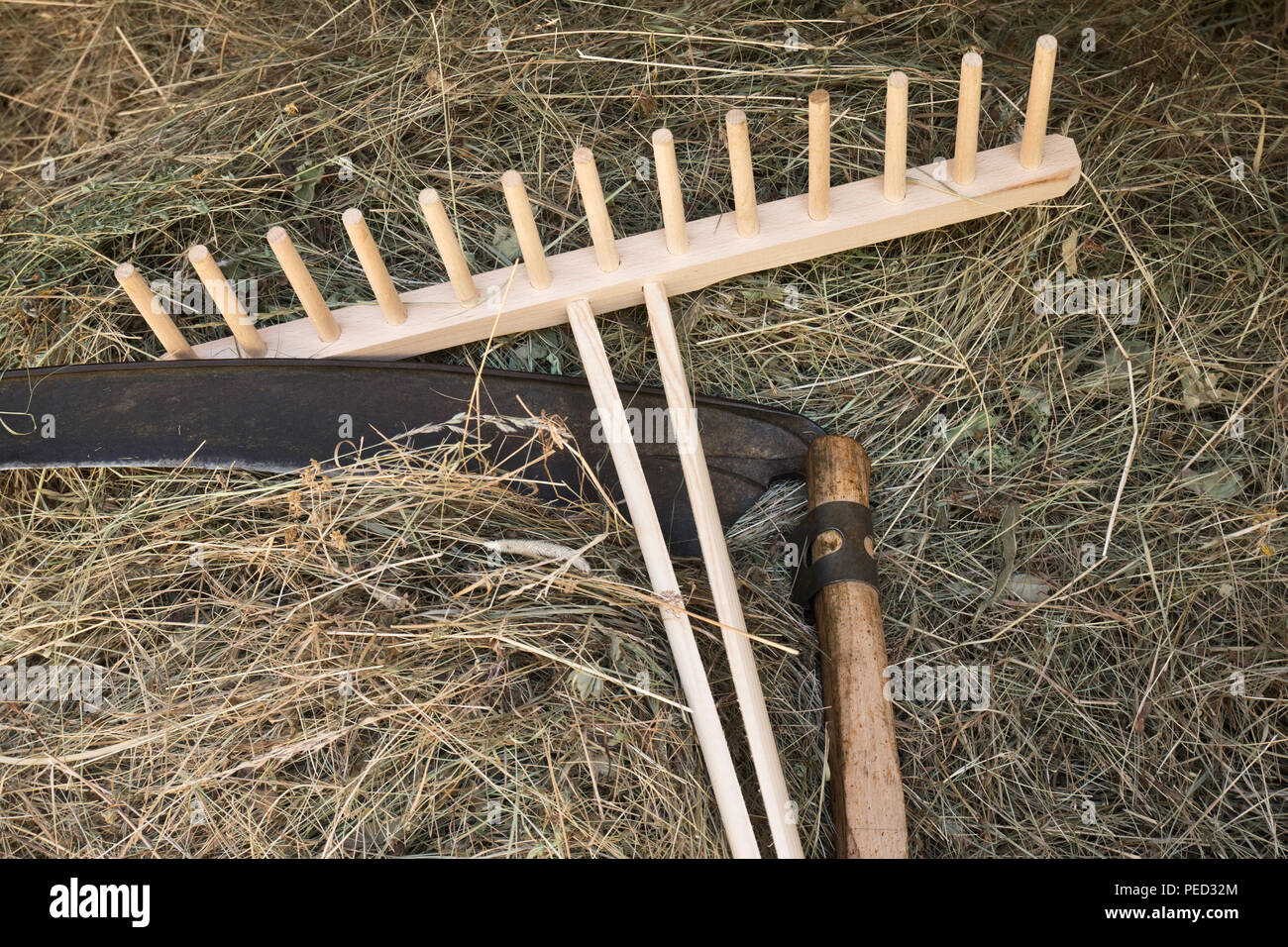 A scythe and a rake with  hay Stock Photo