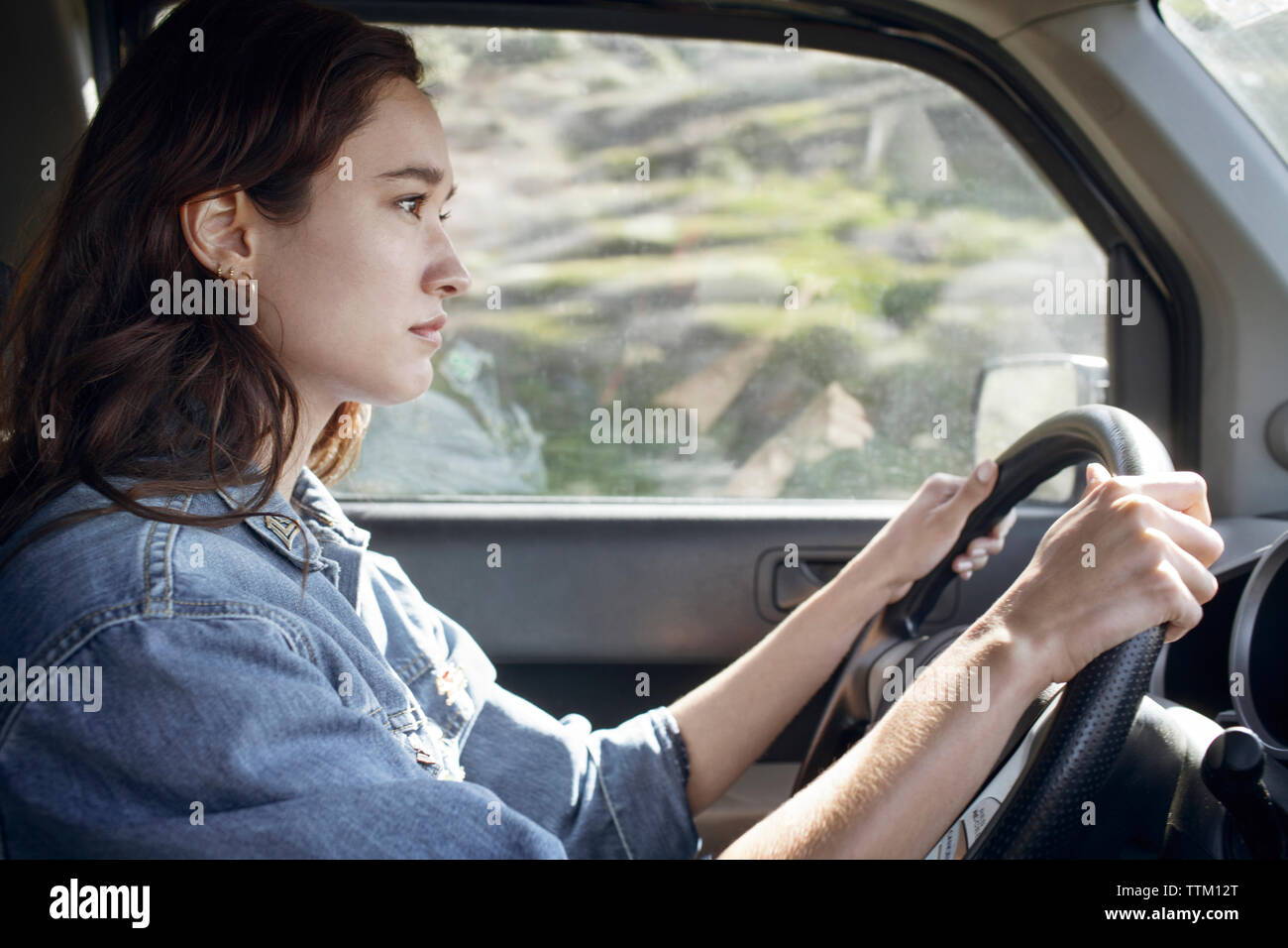 Side view of woman driving car Stock Photo