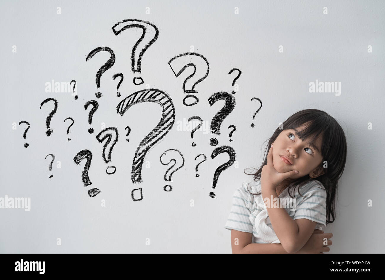 asian little girl thinking with question mark in isolated background Stock Photo