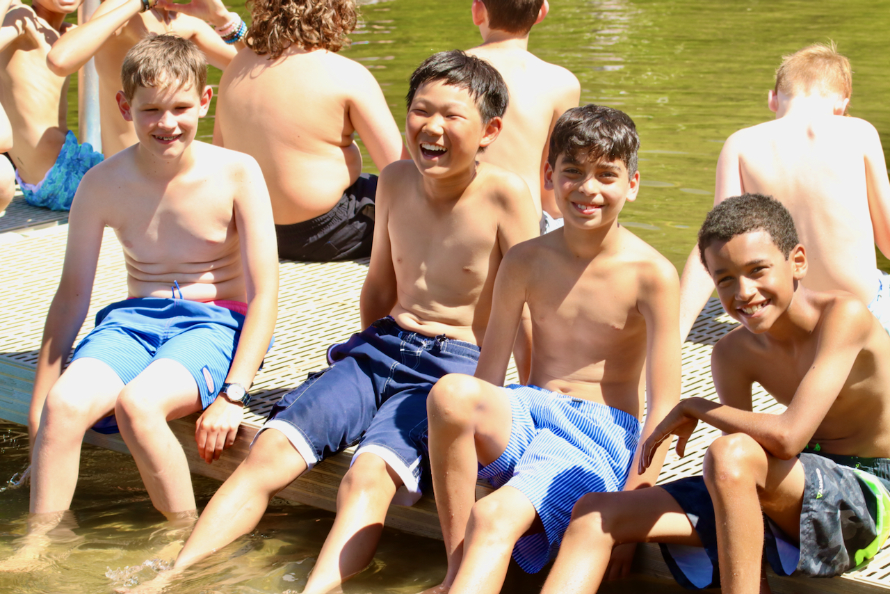 Pemi campers sitting on the dock smiling