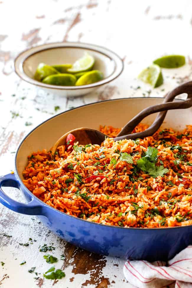 far away view of Restaurant style Mexican Rice on a white table in a blue skillet with limes