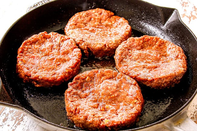 showing how to cook burgers on the stove by adding 4 patties to a cast iron skillet