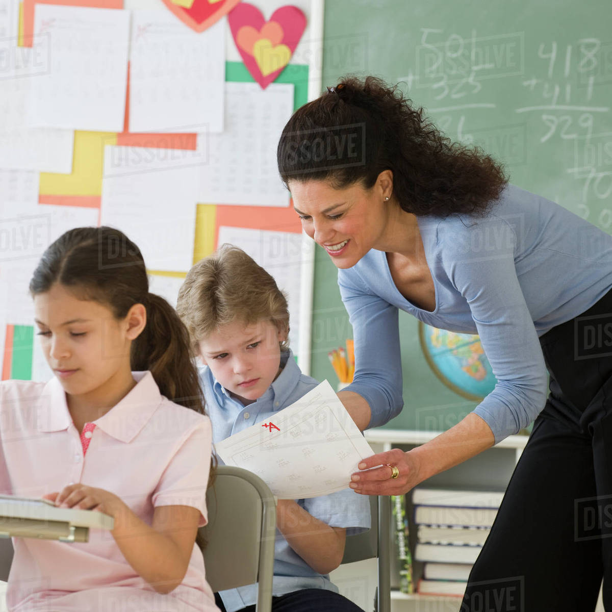 Hispanic teacher talking to student - Stock Photo - Dissolve