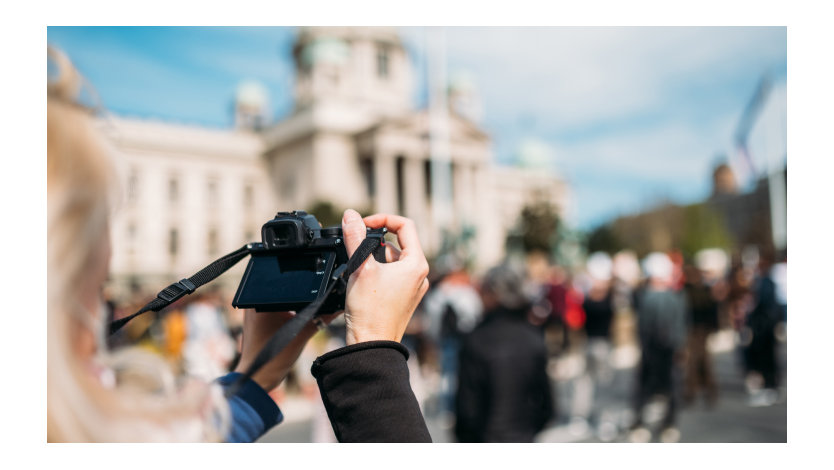 A person with a digital camera photographing a political gathering.