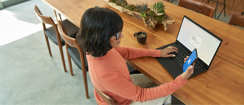 Eine Person, die mit einem Computer an einem Tisch sitzt