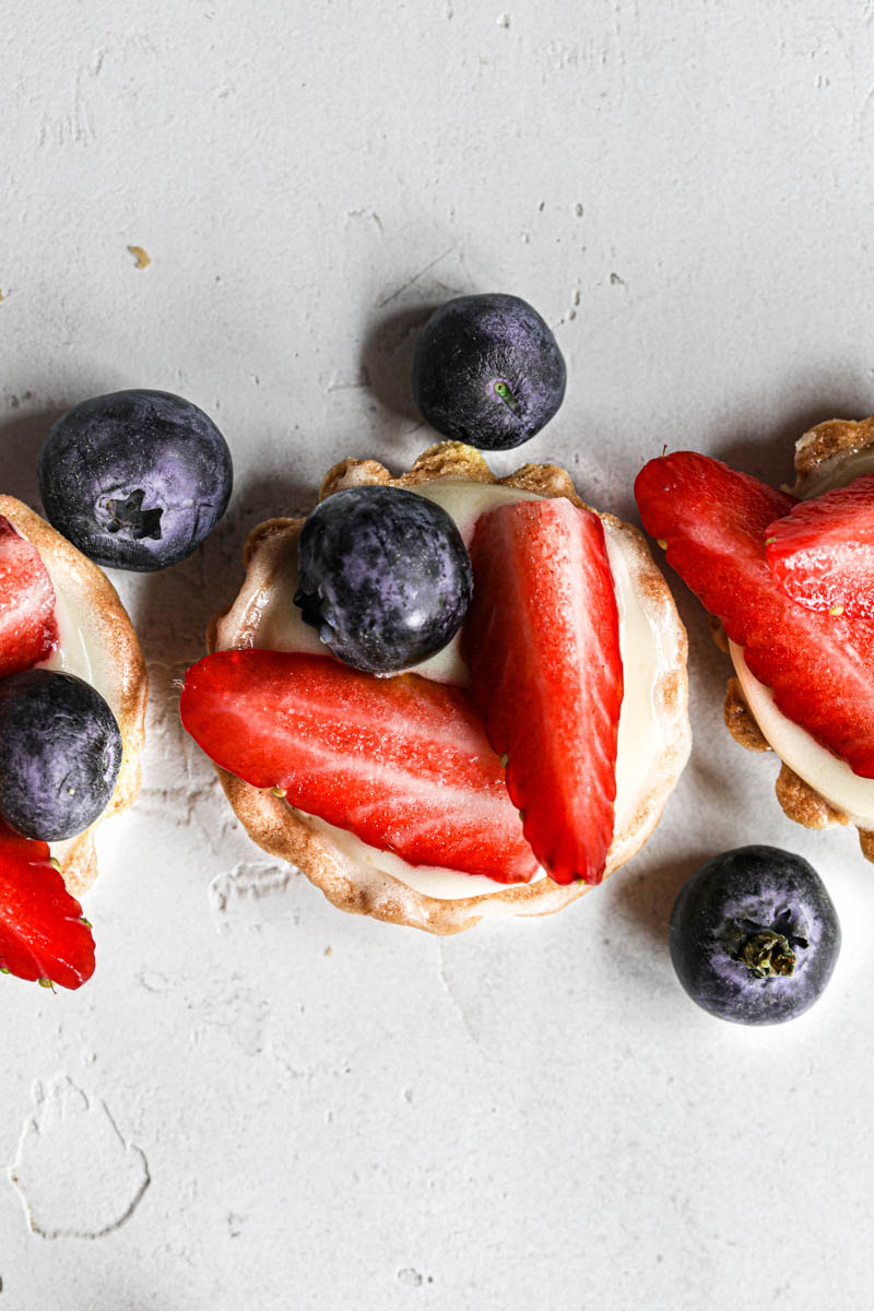 A closeup of 3 mini strawberry lemon tartlets as seen from above.