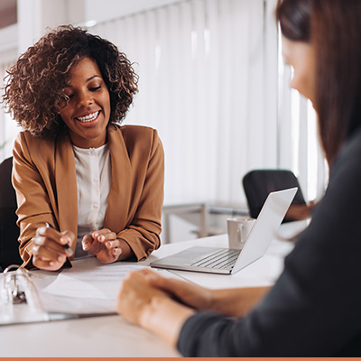 Business woman explains information to client pointing to paperwork