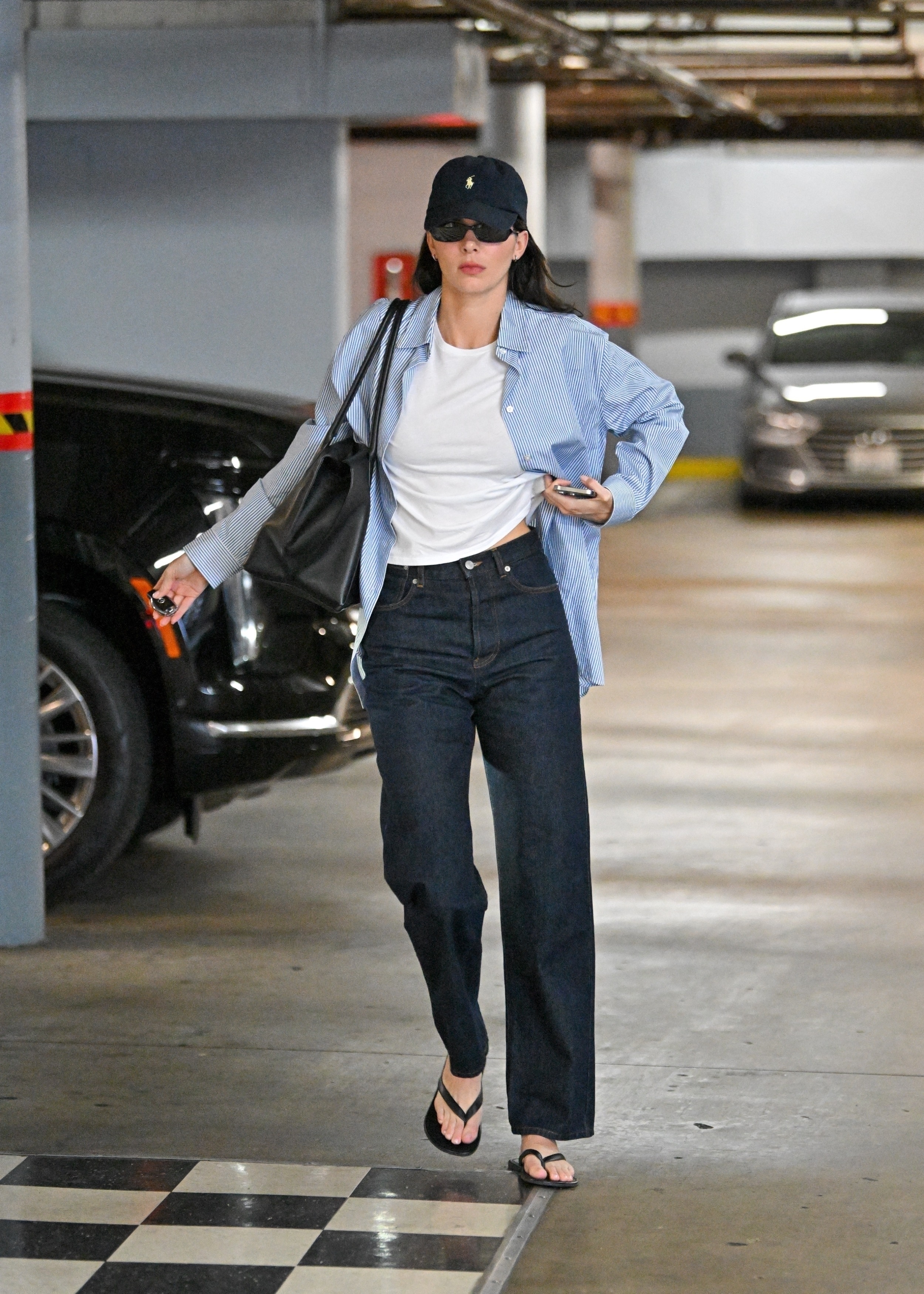 Kendall Jenner wearing a button up shirt and jeans with the row dune sandals
