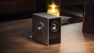 Proyector port&aacute;til LG CineBeam Qube 4K sobre mesa de madera 
